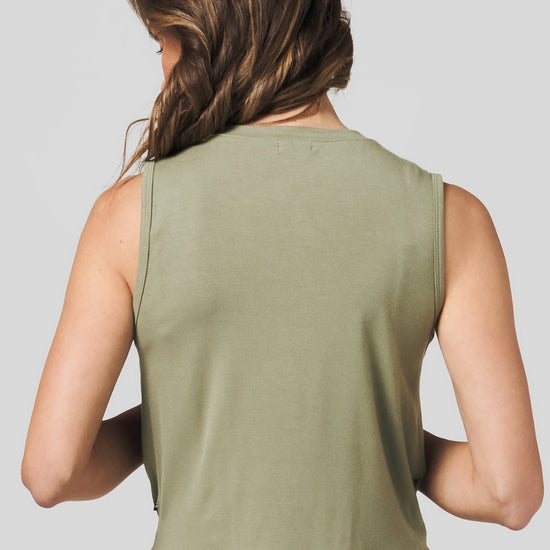 Back of a women wearing a green tank top and black legging.