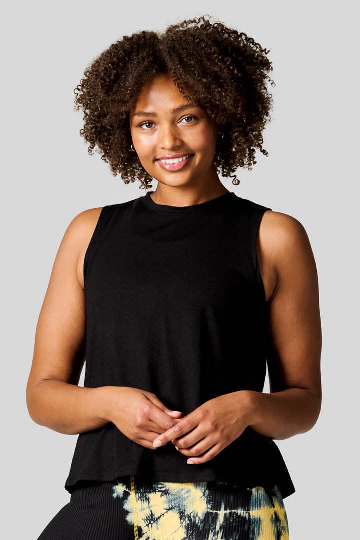Women smiling wearing black high neck tank top.