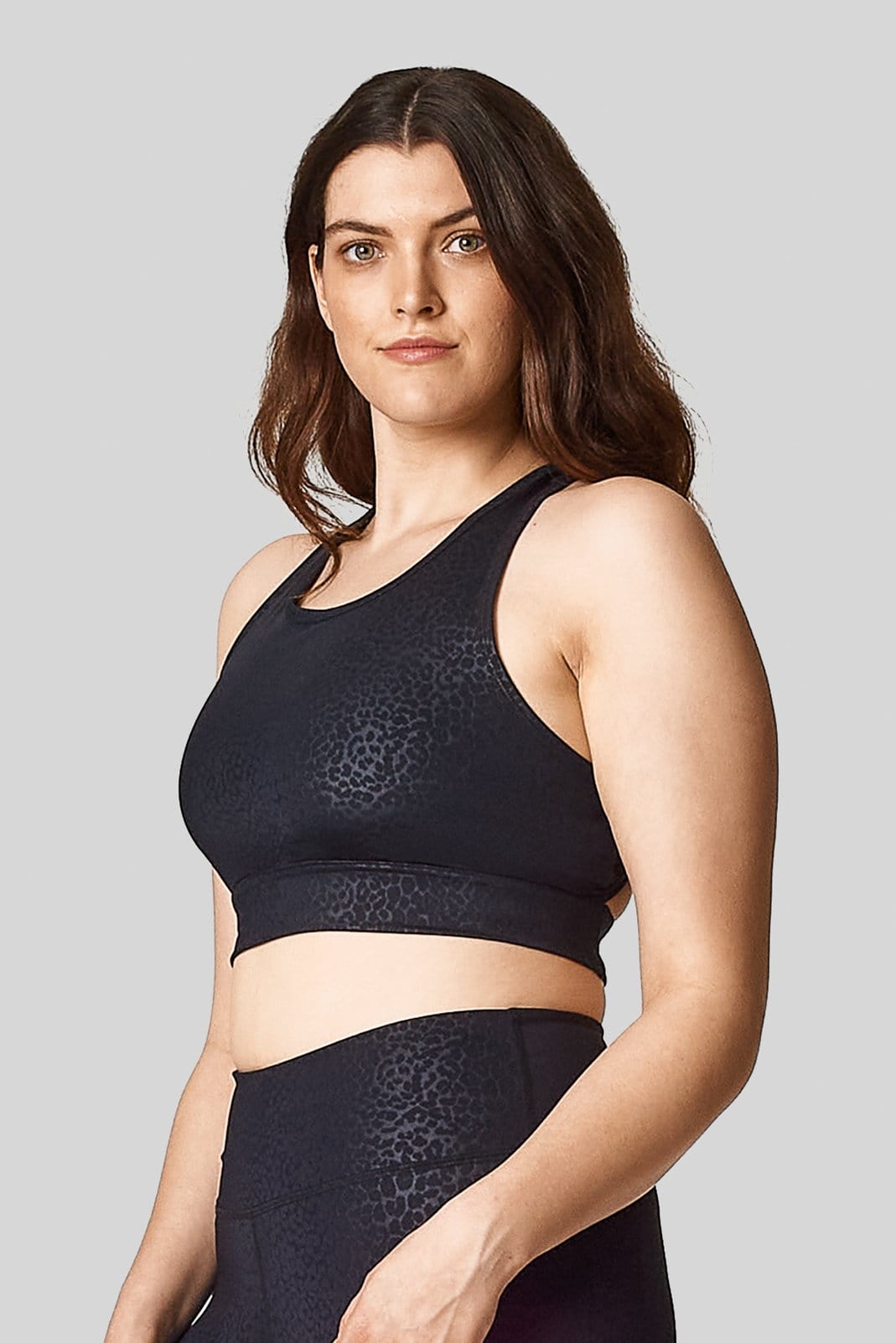 Side view of the black cheetah print sports bra with matching high waisted bike shorts.