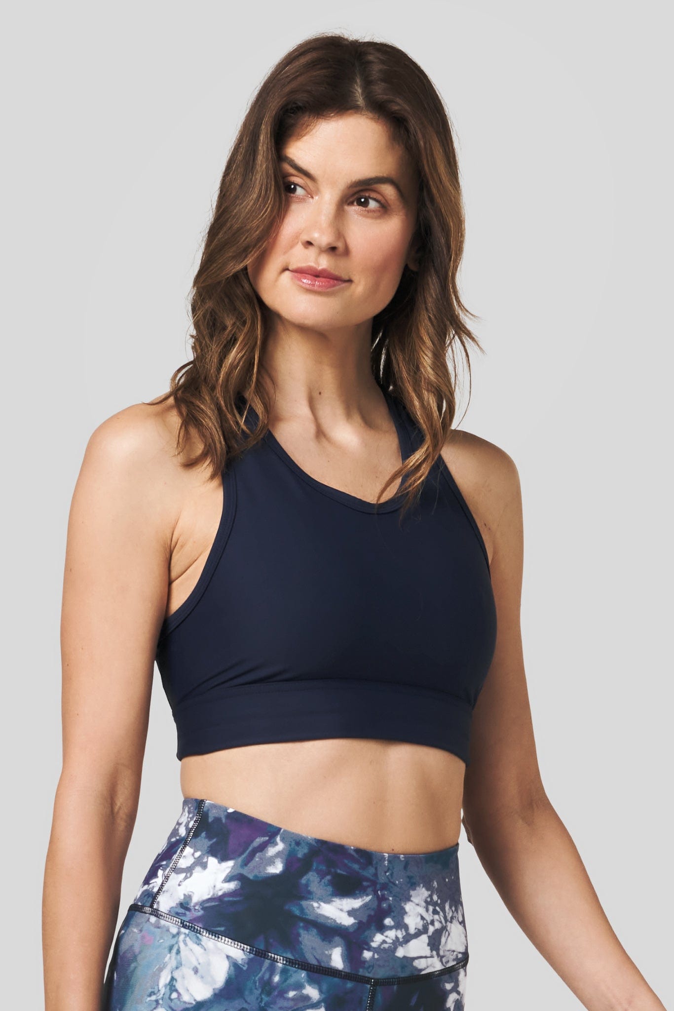 Side of a women wearing a navy sports bra.