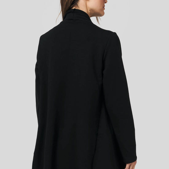 Back of a women wearing a black fleece jacket and black leggings