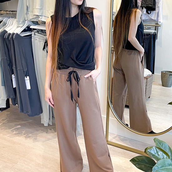 Women wearing wide leg sweatpants in brown with boots and a black tank
