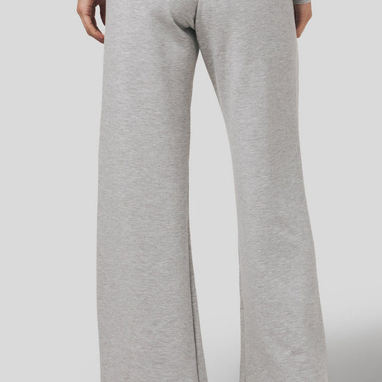 Back of a women wearing a wide leg sweatpants in light heather grey