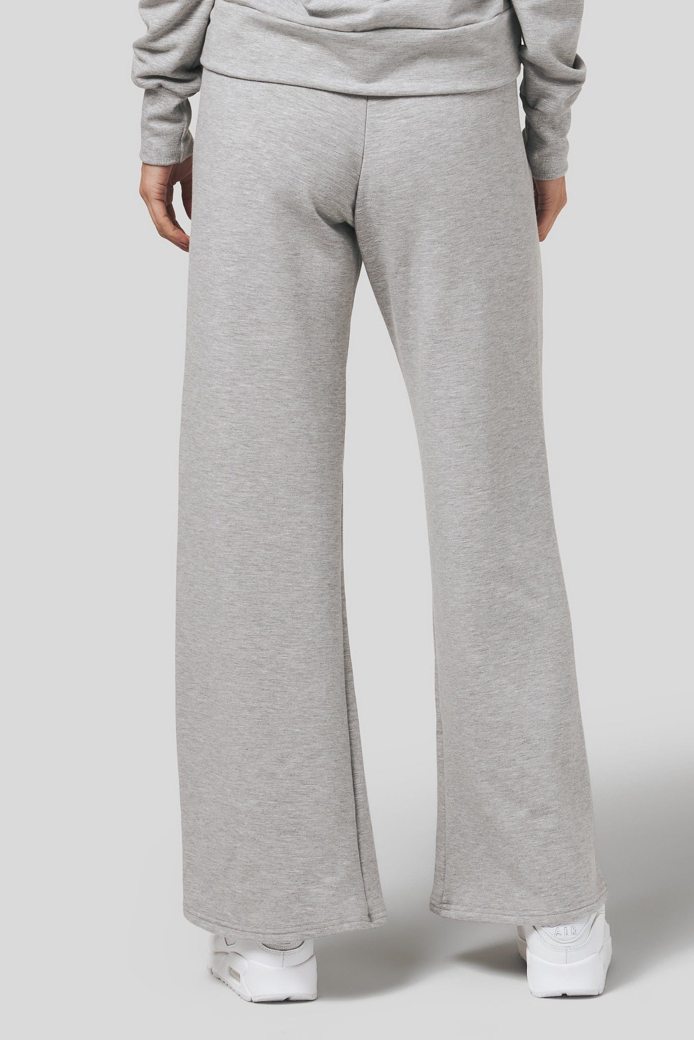 Back of a women wearing a wide leg sweatpants in light heather grey