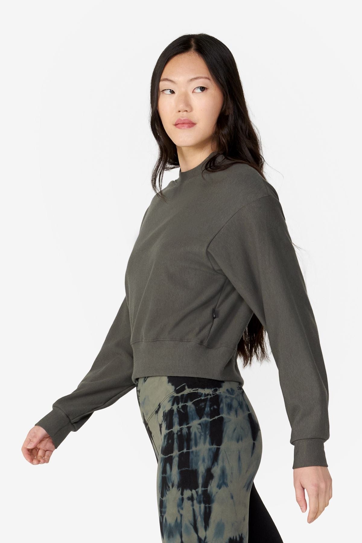girl on her side wearing a dark green long sleeves sweater