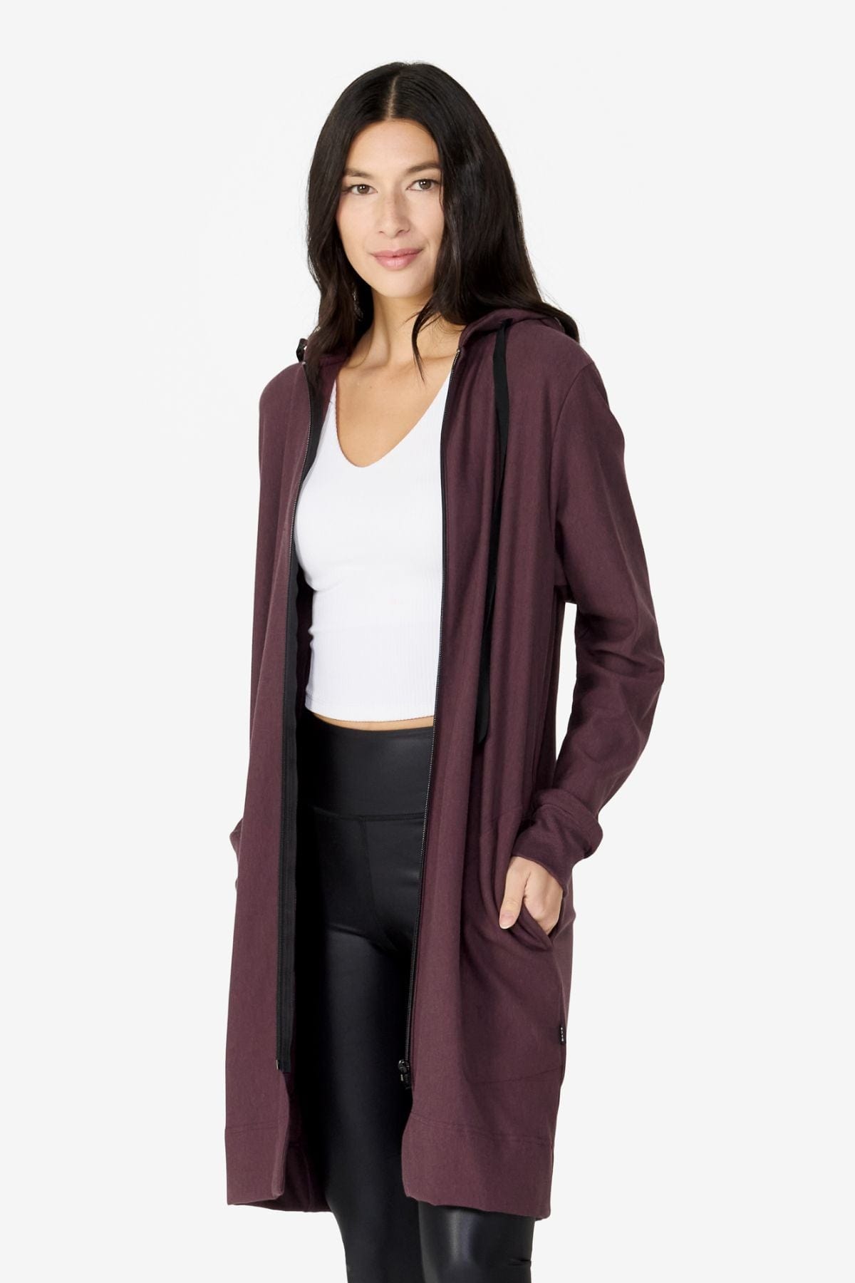 girl wearing long zip up dark brown hoodie with a white top and black leggings