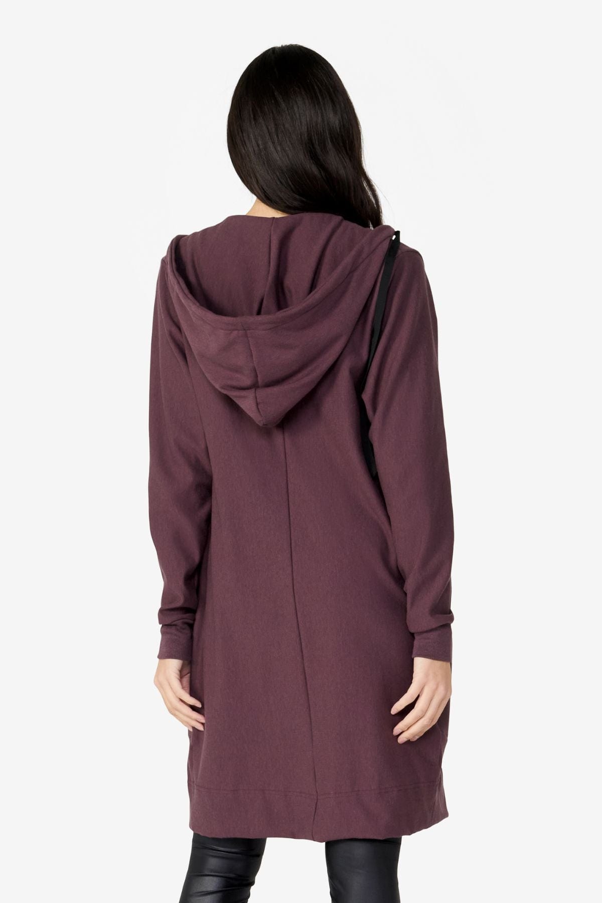 girl back view wearing long zip up dark brown hoodie with a white top and black leggings