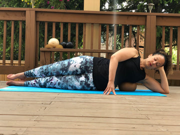 Woman on yoga mat doing breathing techniques and Yamuna Body Rolling.