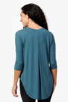 Back of a woman wearing a Teal 3/4 length sleeve shirt