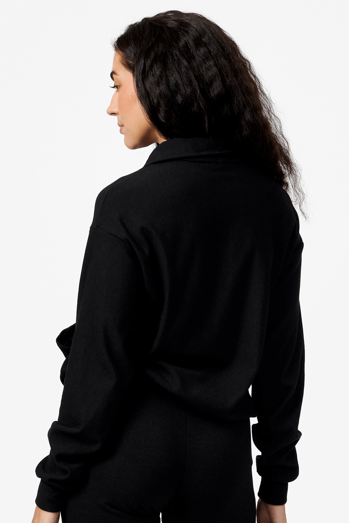 Back of a woman wearing a black half zip sweatshirt