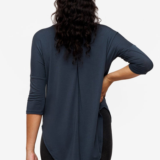 Back of a woman wearing a dark blue 3/4 sleeve shirt