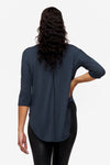 Back of a woman wearing a dark blue 3/4 sleeve shirt