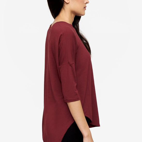 Side of a Woman wearing a deep red 3/4 sleeve shirt