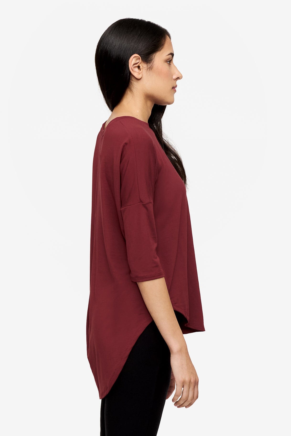 Side of a Woman wearing a deep red 3/4 sleeve shirt