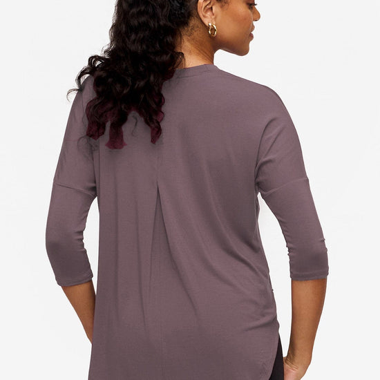 back of a woman wearing a 3/4 sleeve shirt in purple