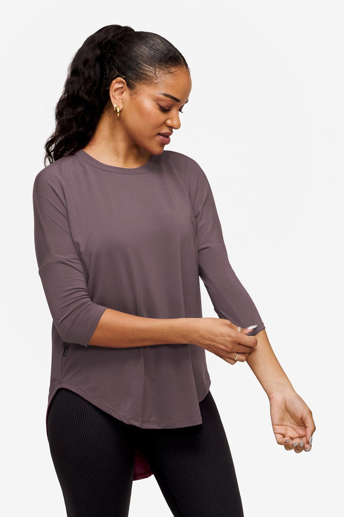 side of a woman wearing a 3/4 sleeve shirt in purple