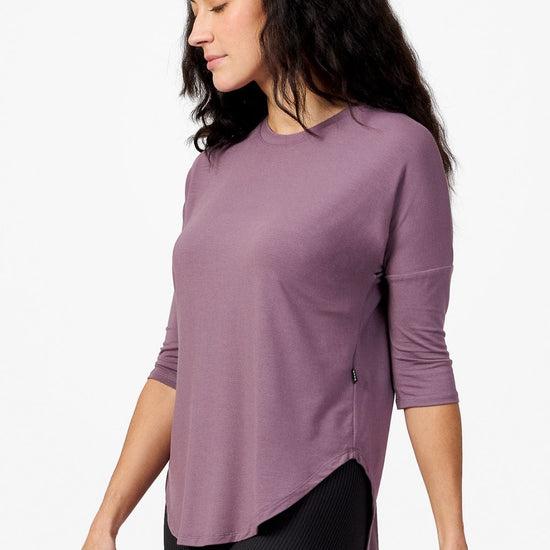 Side of a woman wearing a light purple 3/4 length sleeve shirt