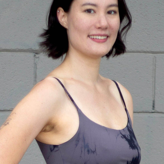 Woman smiling wearing a tie-dye grey swim top