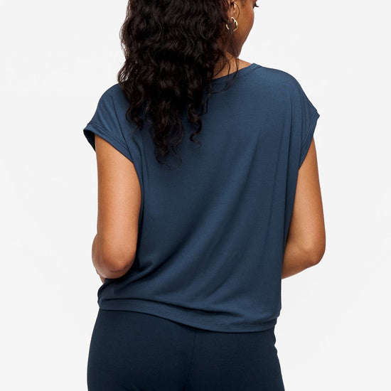 back of a woman wearing a sleeveless top in bright blue