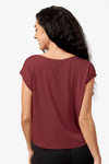 A brunette woman models a burgundy tee shirt. This photo shows the back view of the top which is made from modal and drapes beautifully.