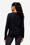 back of a  woman wearing a black loose dolman sleeve long sleeve shirt