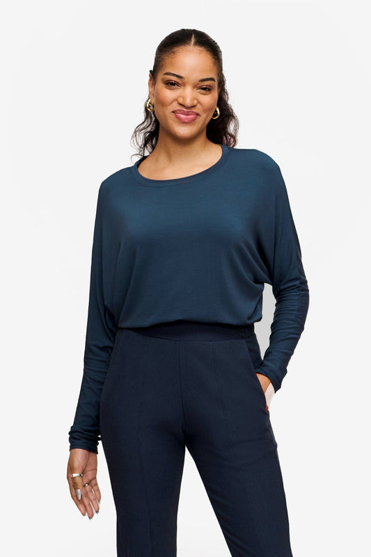 Woman wearing a long sleeve tee with dolman sleeves tucked in