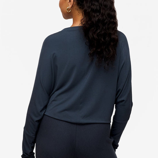 back of a woman wearing a dark blue loose sleeve long sleeve shirt