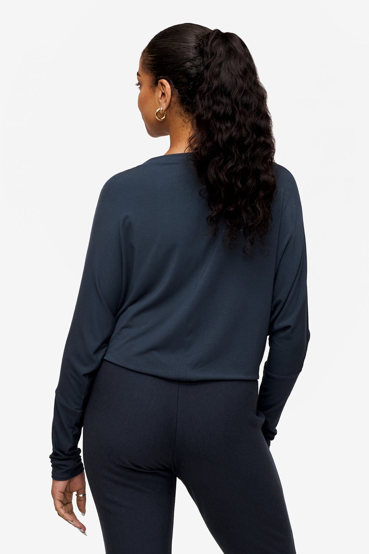 back of a woman wearing a dark blue loose sleeve long sleeve shirt