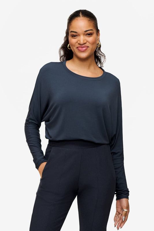 woman wearing a dark blue loose sleeve long sleeve shirt