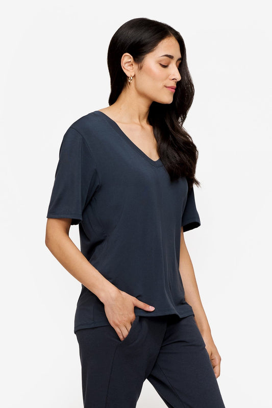 side of a woman wearing dark blue v-neck short sleeve t-shirt