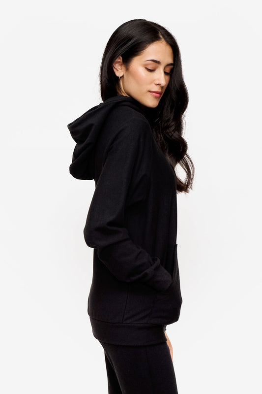 side of a woman wearing a black zipped hoodie