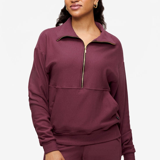 woman wearing half zip sweatshirt in deep pink