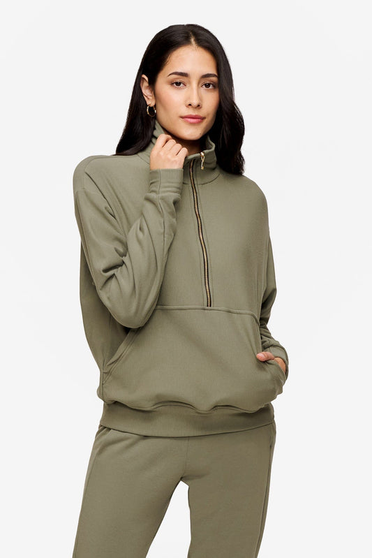 woman wearing half zip sweatshirt in green