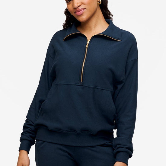 woman wearing half zip sweatshirt in deep blue 