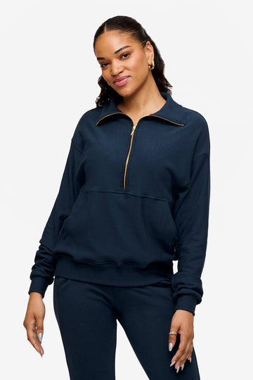 woman wearing half zip sweatshirt in deep blue 