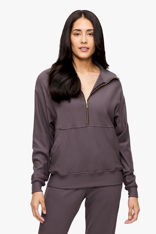 woman wearing half zip sweatshirt in deep purple