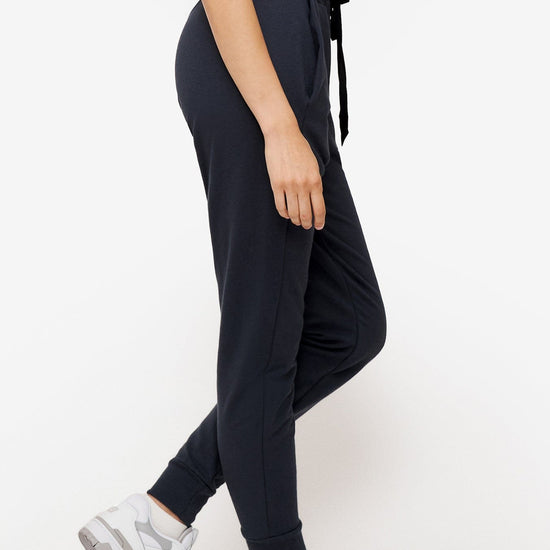 side of a woman wearing dark blue sweatpants with drawstring 