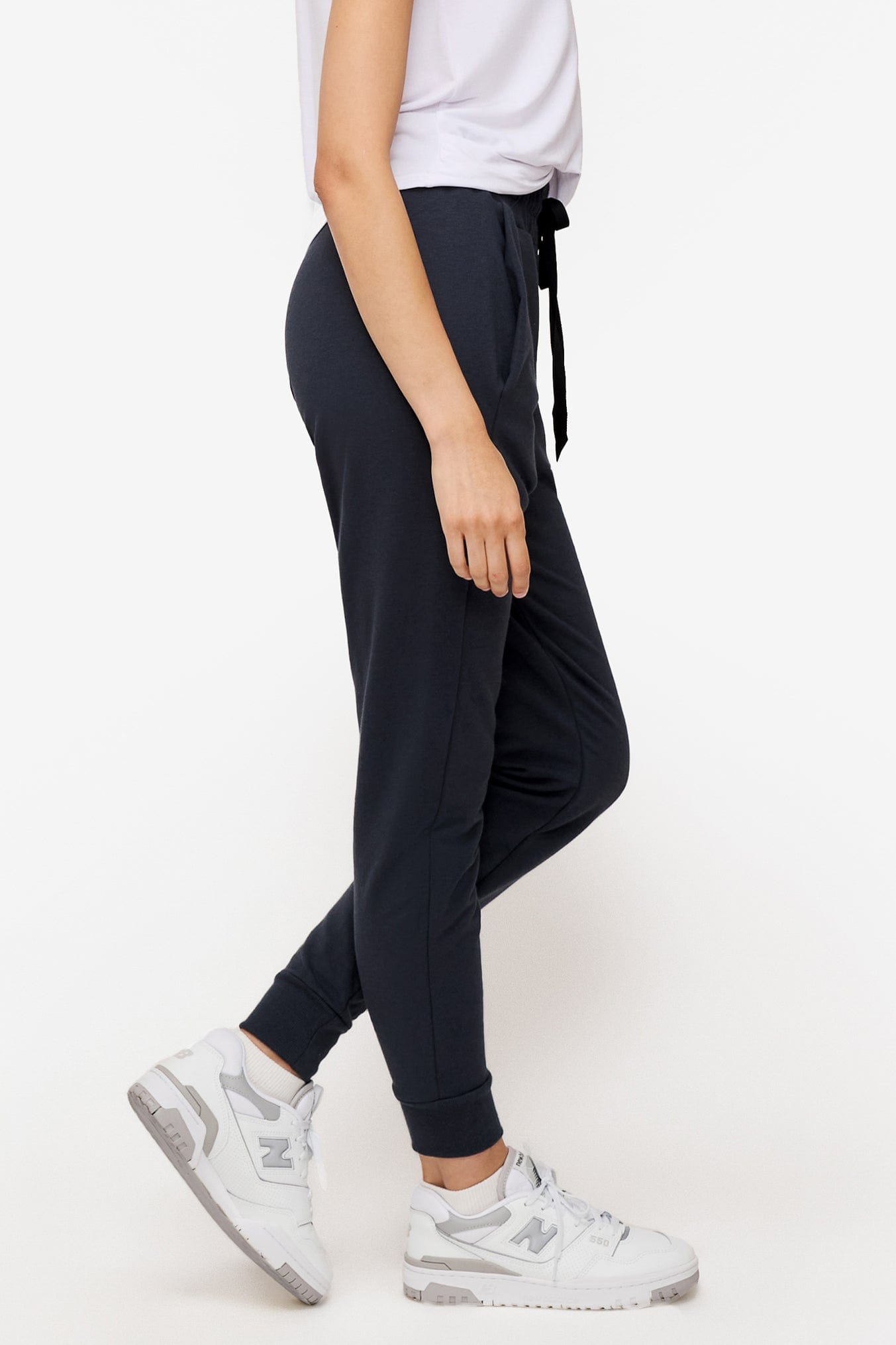 side of a woman wearing dark blue sweatpants with drawstring 