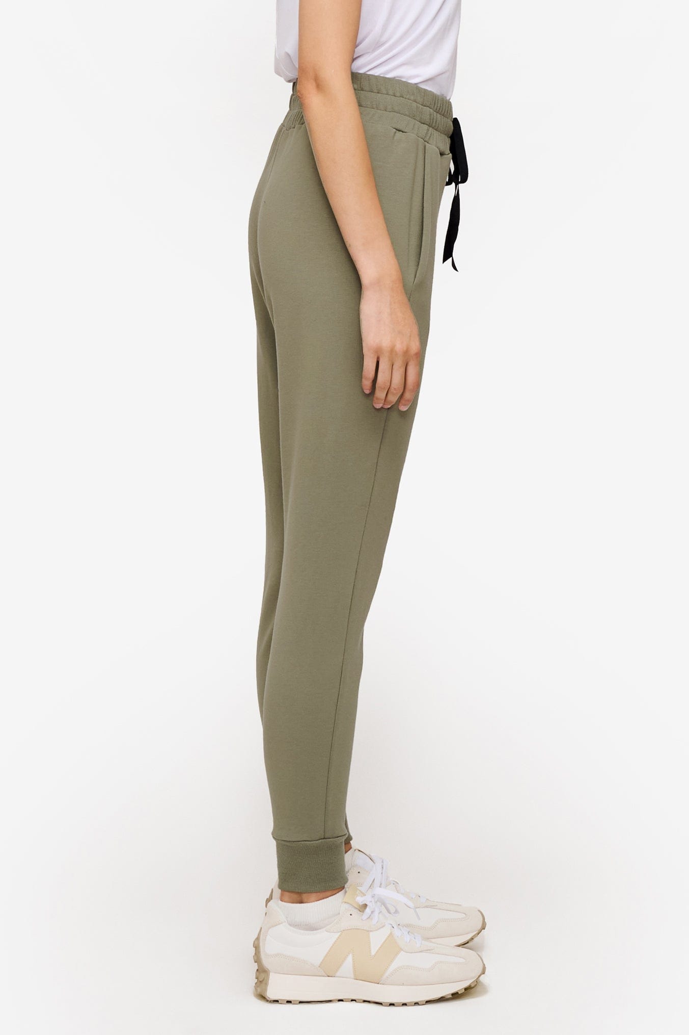 side of a woman wearing green sweatpants with drawstring 