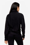 back of a woman wearing a 1/4 zip sweatshirt in black