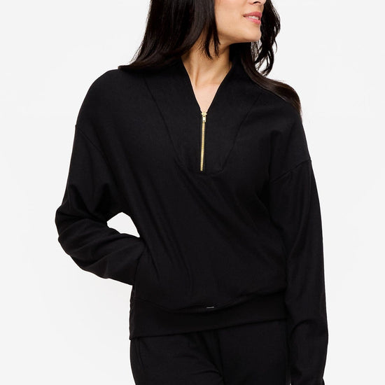 woman wearing a 1/4 zip sweatshirt in black