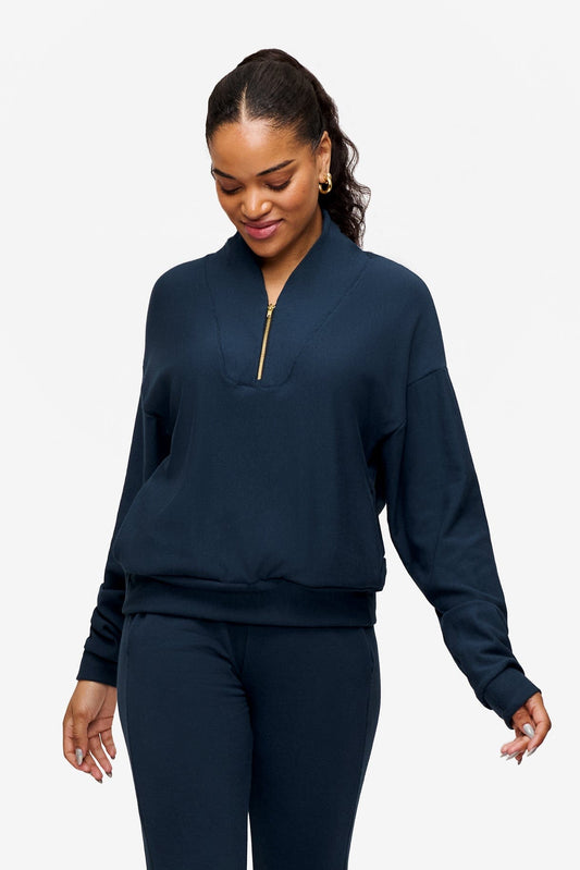 woman wearing a 1/4 zip sweatshirt in deep blue