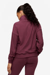 back of a woman wearing a 1/4 zip sweatshirt in deep pink