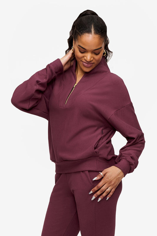 side o a woman wearing a 1/4 zip sweatshirt in deep pink