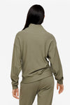 back of a woman wearing a 1/4 zip sweatshirt in green