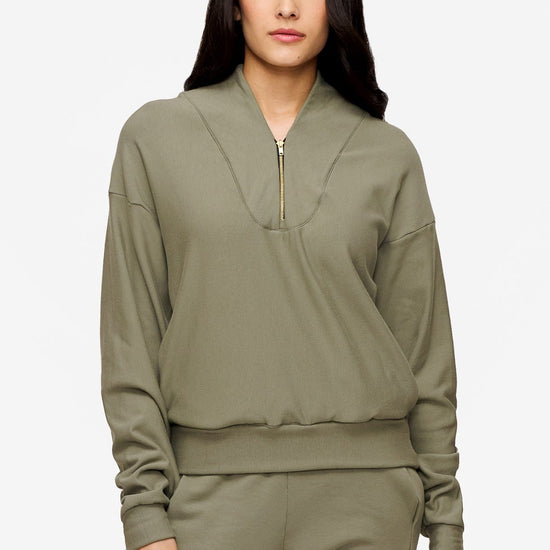 woman wearing a 1/4 zip sweatshirt in green