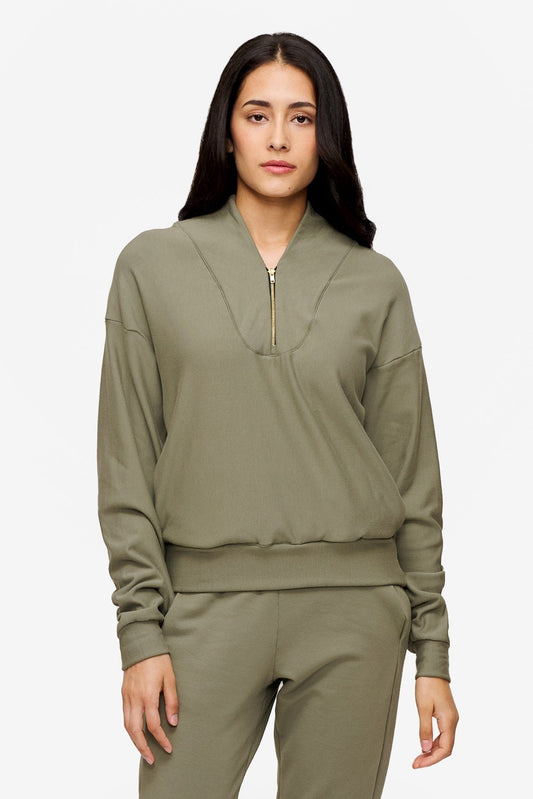 woman wearing a 1/4 zip sweatshirt in green