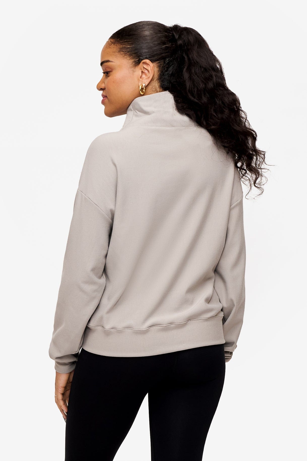 back of a woman wearing a 1/4 zip sweatshirt in grey