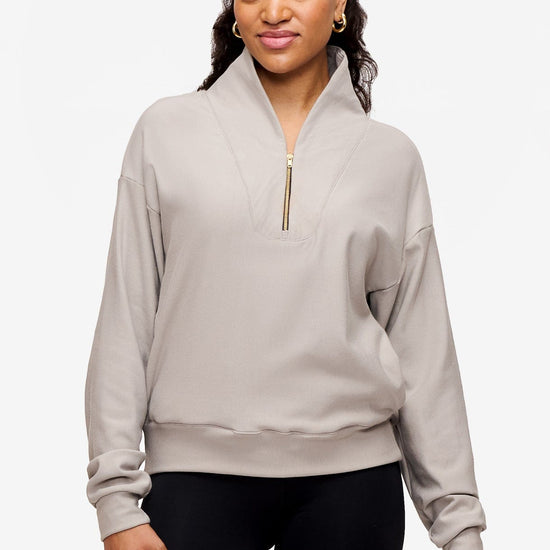 woman wearing a 1/4 zip sweatshirt in grey