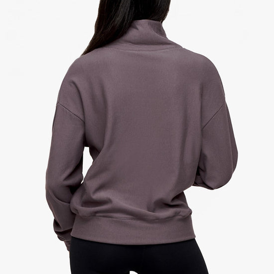 back of a woman wearing a 1/4 zip sweatshirt in deep purple